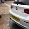 traffic film remover being rinsed from car bodywork